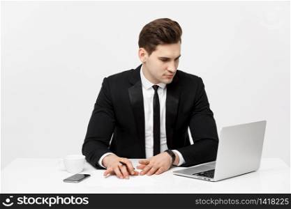 Portrait of a handsome businessman holding smartphone while working on a computer at his desk. He is in a office his notebook in front of him like an insurance or bank manager. Portrait of a handsome businessman holding smartphone while working on a computer at his desk. He is in a office his notebook in front of him like an insurance or bank manager.