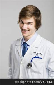 Portrait of a handsome doctor smiling, over a gray background