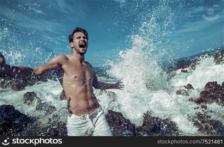 Portrait of a handsome guy jumping into the sea water