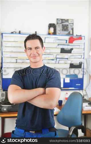 Portrait of a handsome smiling mechanic with arms crossed