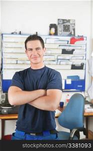 Portrait of a handsome smiling mechanic with arms crossed