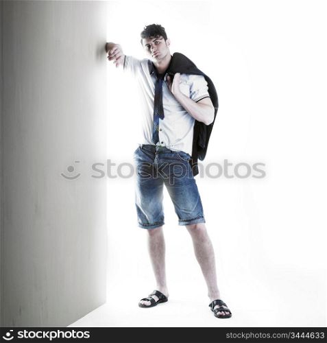 Portrait of a handsome stylish man standing against a wall
