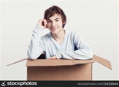 Portrait of a handsome young man inside a cardbox