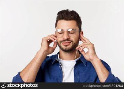portrait of a handsome young man listening to music over white background. portrait of a handsome young man listening to music over white background.