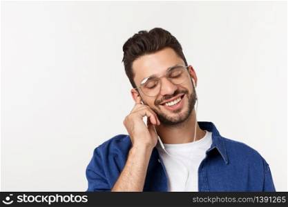 portrait of a handsome young man listening to music over white background. portrait of a handsome young man listening to music over white background.