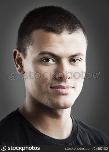 Portrait of a handsome young man, over a gray background