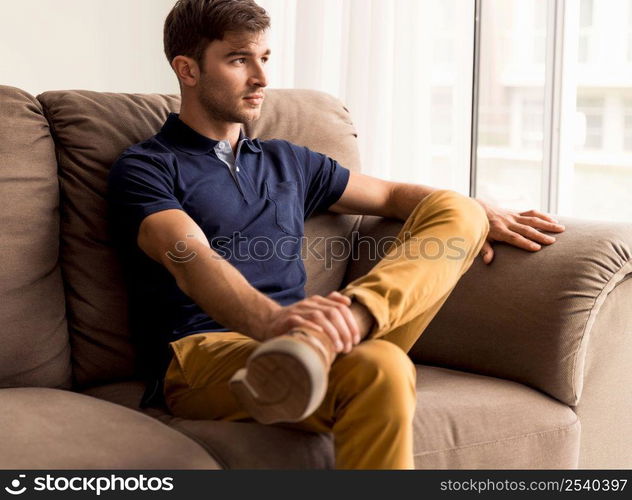 Portrait of a handsome young man sitting on the sofa