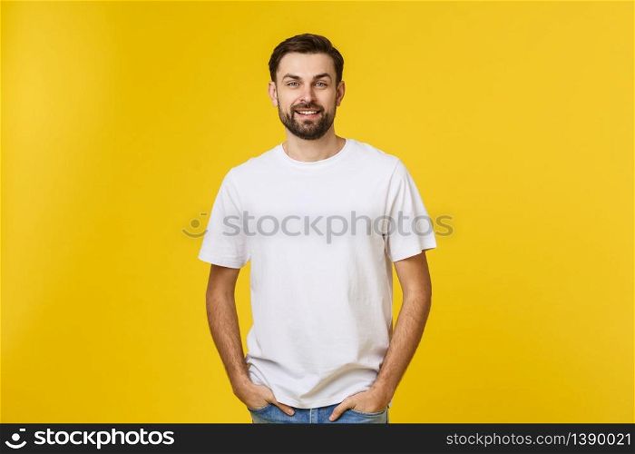 Portrait of a handsome young man smiling against yellow background.. Portrait of a handsome young man smiling against yellow background