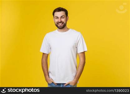 Portrait of a handsome young man smiling against yellow background.. Portrait of a handsome young man smiling against yellow background