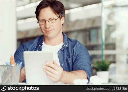 Portrait of a handsome young man working with a tablet in an office