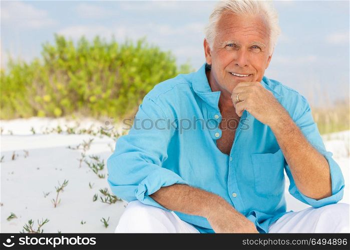 Portrait of a happy attractive handsome senior man sitting down outside on a beach and smiling. Portrait of Attractive Handsome Senior Man on Beach