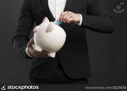 Portrait of a happy businessman holding a piggy bank