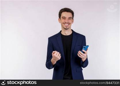 Portrait of a happy businessman using smartphone and doing winner gesture clenching fist over white background. Using mobile phone, typing sms message.