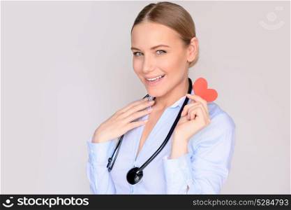 Portrait of a happy cardiologist doctor with conceptual paper heart in hands, successful treatment, good medical specialist, healthy life concept