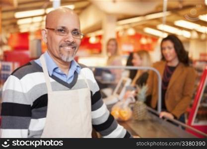 Portrait of a happy cashier with customer in the background