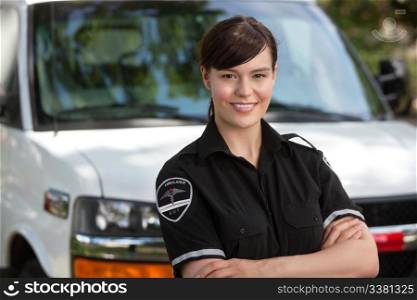 Portrait of a happy confident woman paramedic standing in front of ambulance