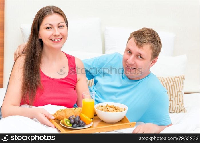 Portrait of a happy couple with breakfast on a tray