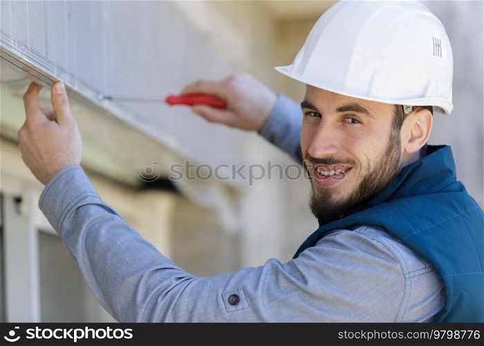 portrait of a happy electrician on a ladder