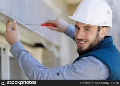 portrait of a happy electrician on a ladder