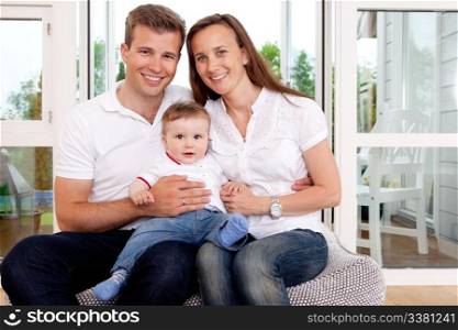 Portrait of a happy family looking at the camera in a home interior