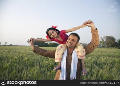 Portrait of a happy father carrying daughter on shoulders