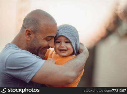 Portrait of a Happy Father with Little Son on His Hands Outdoors. Enjoying Fatherhood. Spending Time Together. Family Love Concept.. Happy Father with Little Son