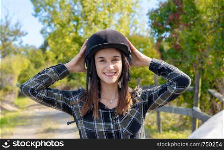 Portrait of a happy female jockey with an helmet
