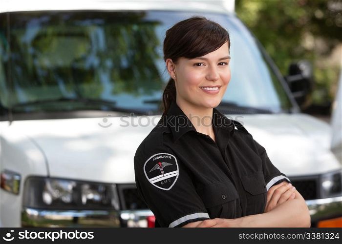 Portrait of a happy friendly female paramedic standing in front of ambulance