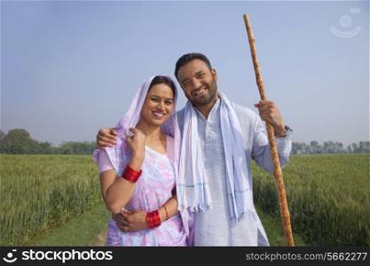 Portrait of a happy Indian couple standing in a field