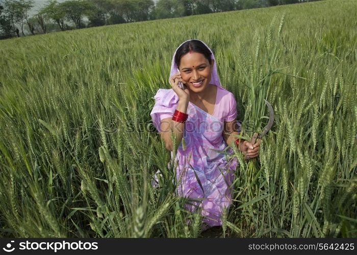 Portrait of a happy Indian female farm worker talking on cell phone
