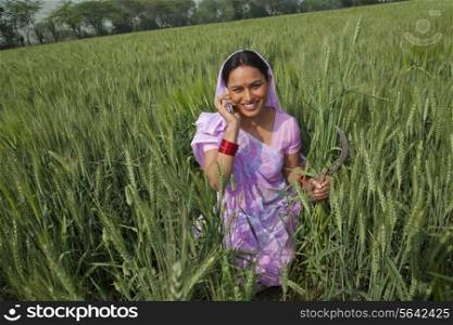 Portrait of a happy Indian female farm worker talking on cell phone