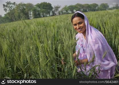 Portrait of a happy Indian female farm worker working in the field