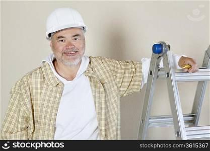 Portrait of a happy male contractor over colored background