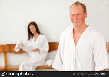 Portrait of a happy man in a bathrobe in a spa reception area