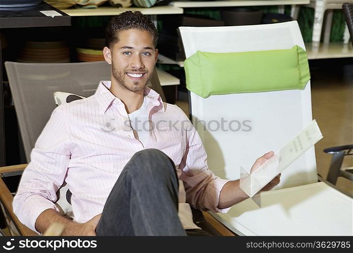 Portrait of a happy man sitting on chair in store