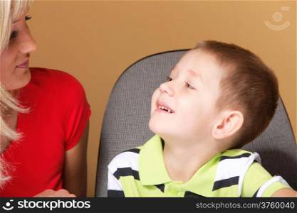 Portrait of a happy mature mother with child 6 years boy brown background