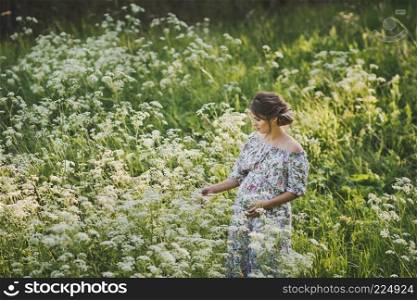 Portrait of a happy pregnant woman in a clearing of white flowers kupyr forest.. Simple female beauty in the meadow of flowers cupira forest 1713.