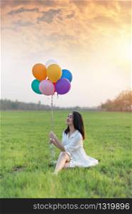 Portrait of a happy pretty woman with balloons in green field. happy pretty woman with balloons