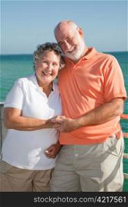 Portrait of a happy senior couple enjoying a seaside vacation.