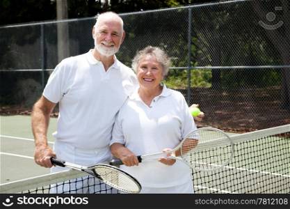 Portrait of a happy senior couple on the tennis courts.