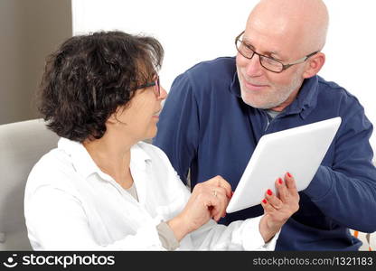 Portrait of a happy senior couple using a tablet digital