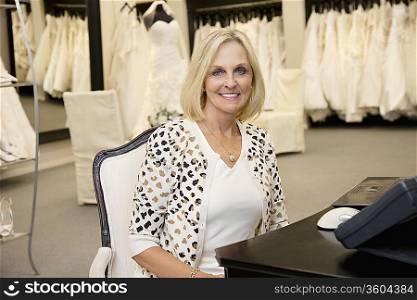 Portrait of a happy senior woman sitting in bridal store