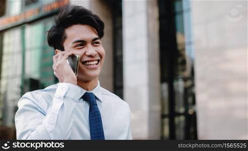 Portrait of a Happy Smiling Businessman Talking on Mobile Phone in the Urban City. Lifestyle of Modern People. Modern Building as background