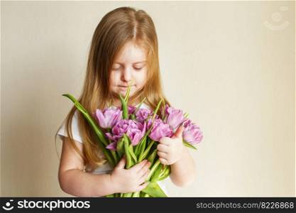 portrait of a happy smiling litlle girl with bouquet of flowers tulips in her hands. portrait of litlle girl with bouquet of flowers tulips in her hands