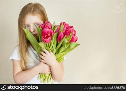 portrait of a happy smiling litlle girl with bouquet of flowers tulips in her hands. portrait of litlle girl with bouquet of flowers tulips in her hands