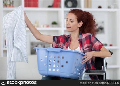 portrait of a happy woman washing clothes in washing machine
