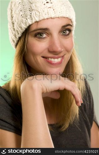 portrait of a happy woman with a winter cap. portrait of a happy woman with a winter cap in front of green background