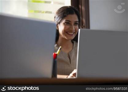 PORTRAIT OF A HAPPY WOMAN WORKING IN OFFICE