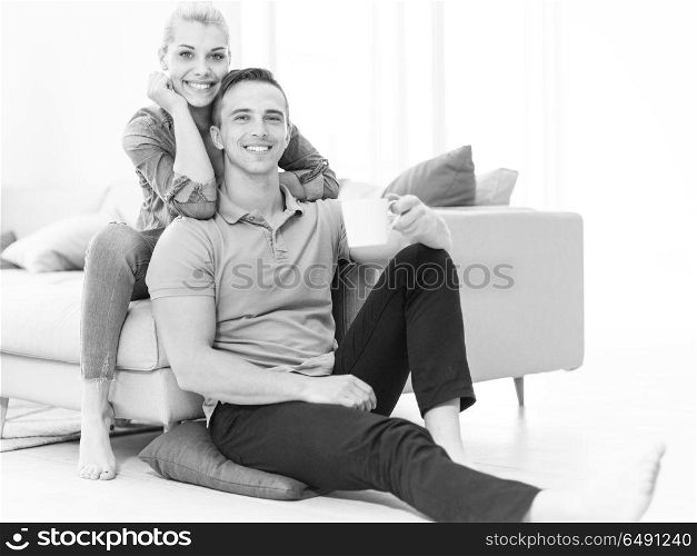 Portrait of a happy young beautiful couple hugging and drinking coffee in their new home. Happy couple in their new home
