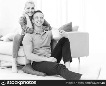 Portrait of a happy young beautiful couple hugging and drinking coffee in their new home. Happy couple in their new home